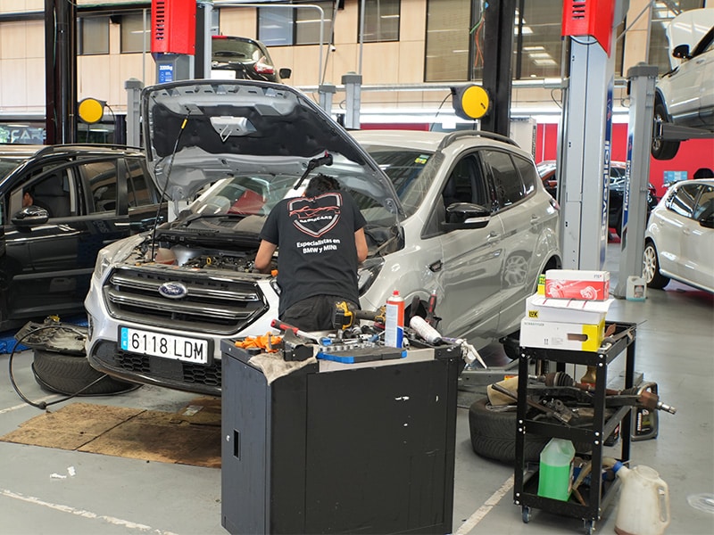 Mecánico de Dasercars trabajando en el motor de un todoterreno con el capó abierto